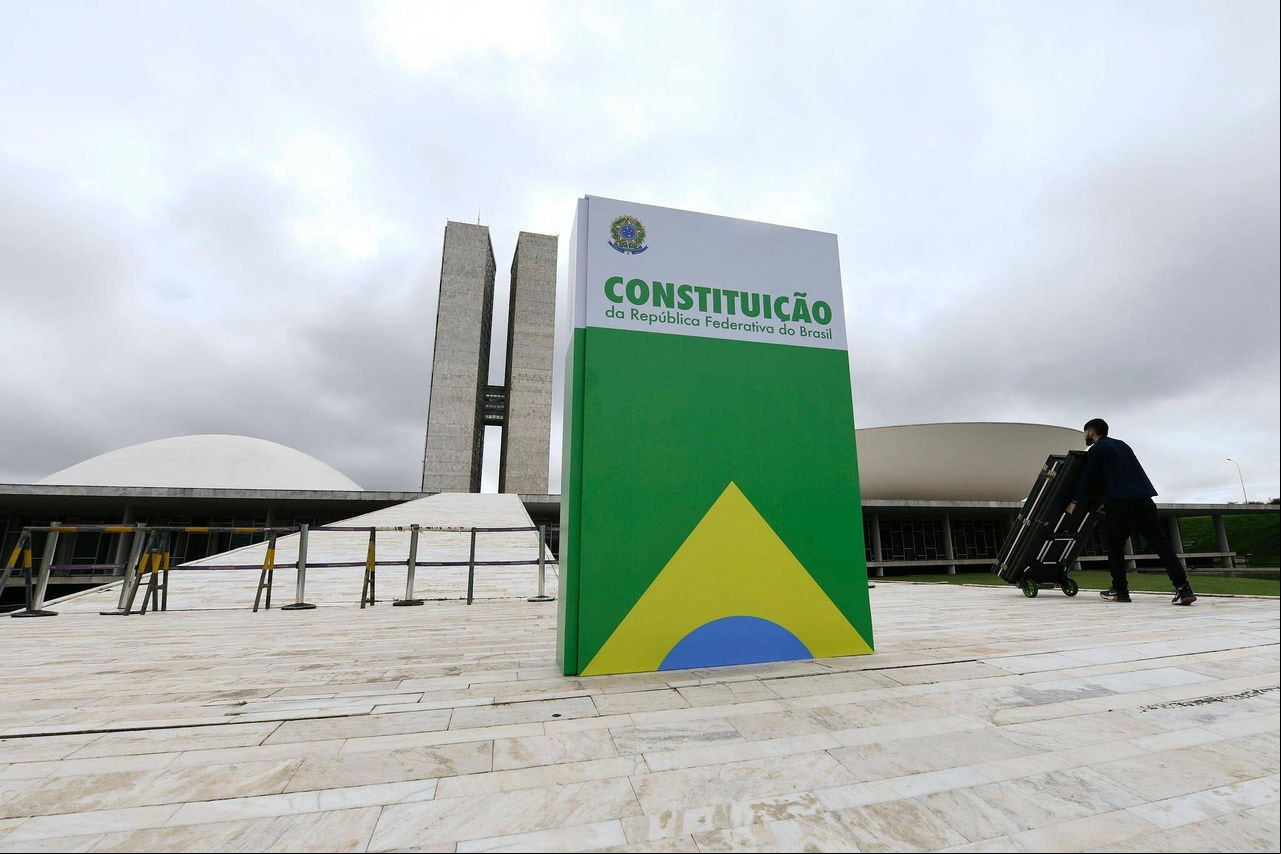 No dia que marca um ano dos atos de 8 de janeiro, réplica da Constituição Federal de 1988, em tamanho gigante, é exibida em frente ao Congresso Nacional
